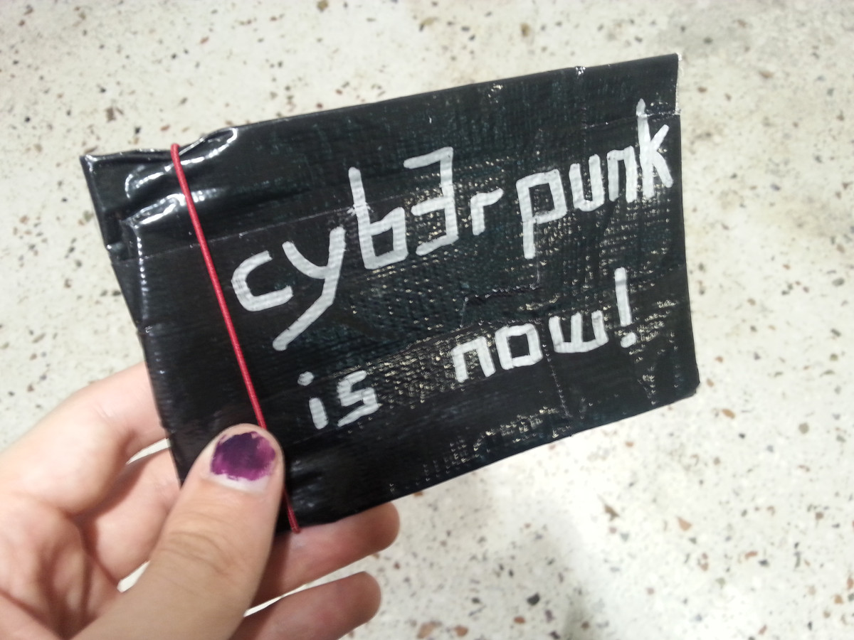 A person holding a DIY Faraday bag with "cyberpunk is now" written on
it.