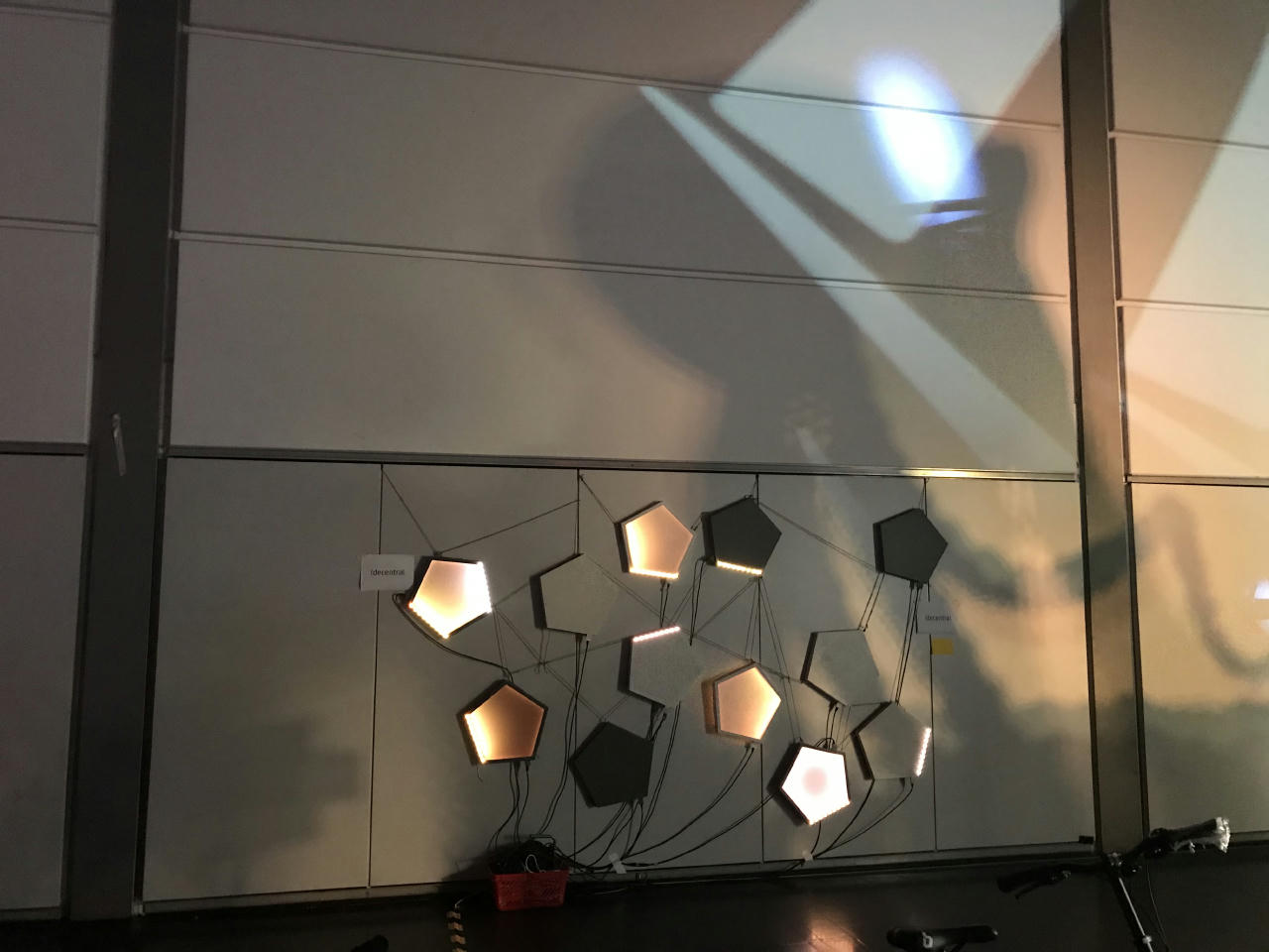 Some art-like connected electronics on a shaded wall.